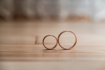 Pair of wedding golden rings on the yellow wooden floor