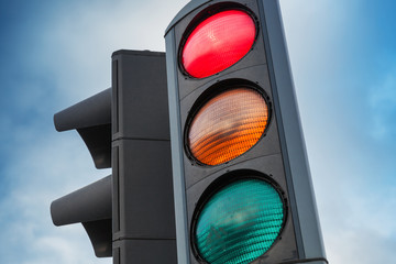 Urban traffic lights over blue cloudy sky