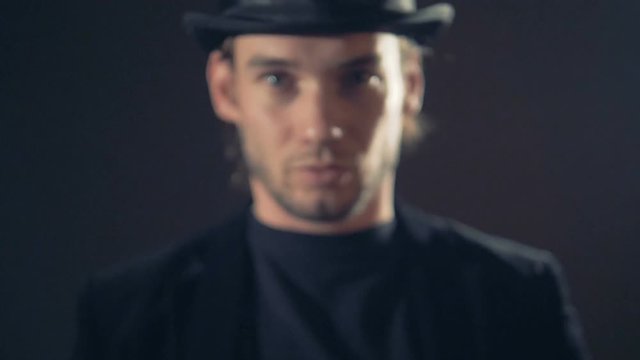 Slow motion evil wizard, magician looking and throwing a white piece of cloth into camera. 4K.