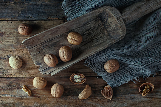 .Walnuts in a wooden scoop on an old village table. Low key.