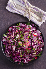 Red cabbage, radish, spring onion, parsley and sesame seeds salad. Vegetarian salad, healthy food concept. View from above, top, vertical
