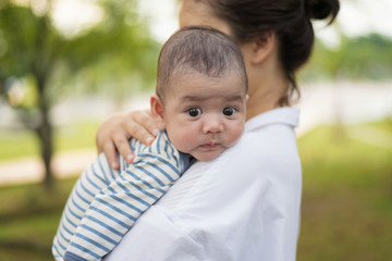Little baby resting on his mother's shoulder. Portrait of asian mother and infant.Family, child and parenthood concept