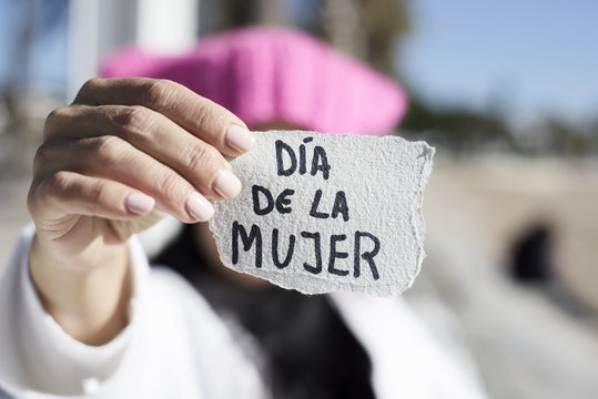 woman with pink hat and text womens day in spanish