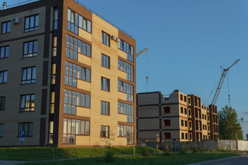New apartment building in the background of unfinished house