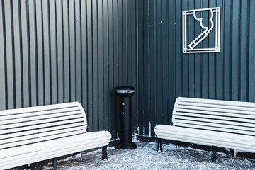 Zone for smoking with ash bin and wooden white benches. Permission for smoking in special place....
