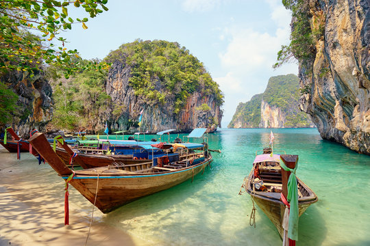 Beautiful landscape with traditional longtail boats, rocks, cliffs, tropical beach. Krabi, Thailand.