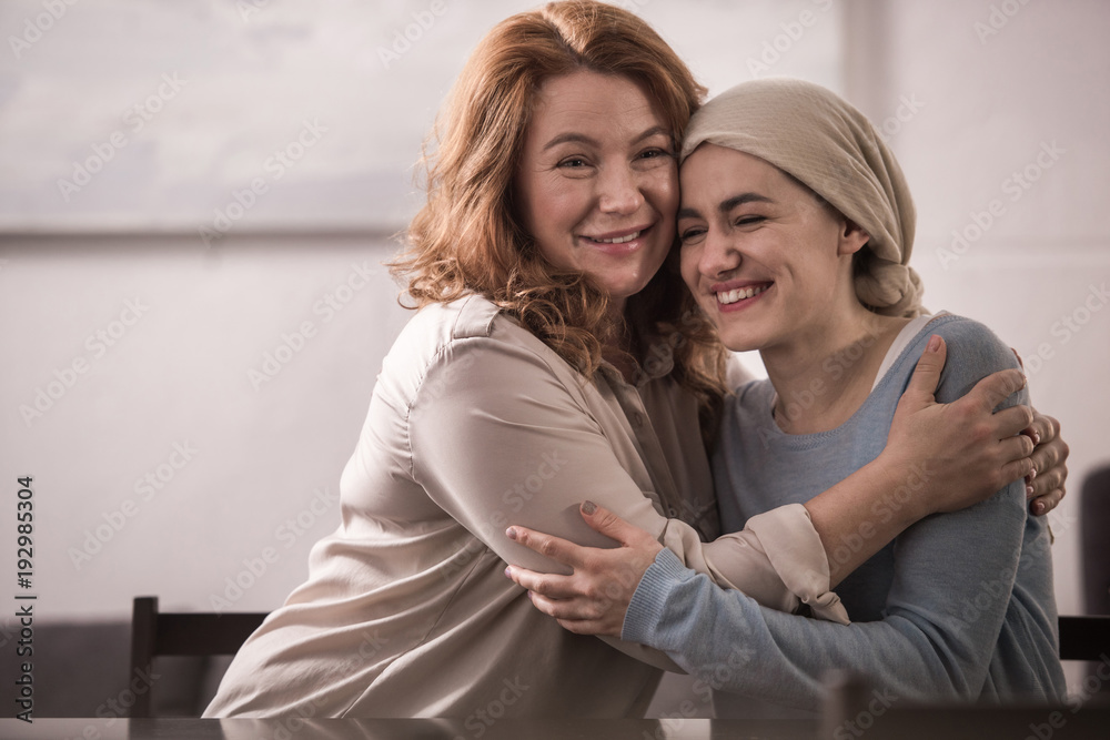 Wall mural happy mother and sick adult daughter in kerchief hugging and smiling together