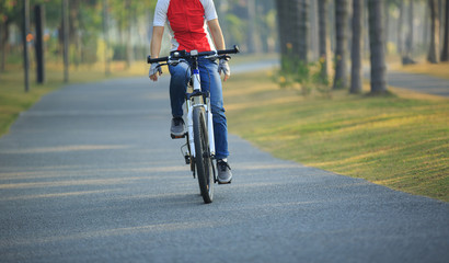 Fototapeta na wymiar woman cyclist riding bike in tropical park