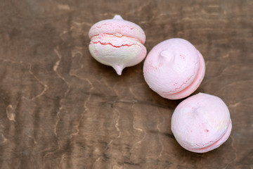 pink sweets lie on a brown background