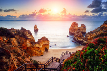 beautiful Atlantic ocean view horizon with sandy beach,  rocks and waves at sunrise. Algarve, ...