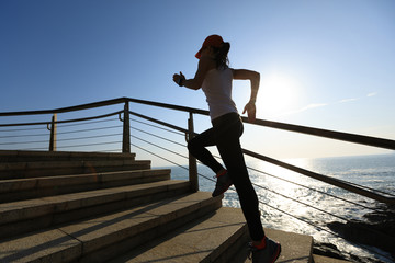 Fototapeta premium sporty fitness female runner running upstairs on coast trail