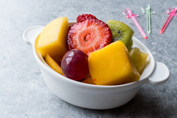 Fototapeta na wymiar Mini Fruit Salad with Strawberry, Kiwi, Mango and Grape in White Ceramic Bowl.