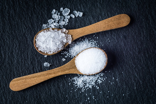 Different types of salt. Top view on two wooden spoons