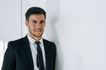  portrait of young  businessman smiling at the airport with suit