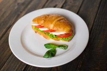 Fresh croissant with ham and salad