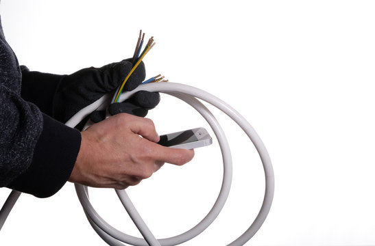 Ein Mann recherchiert mit dem Handy &uuml;ber einzelne Phasen einer Starkstromleitung