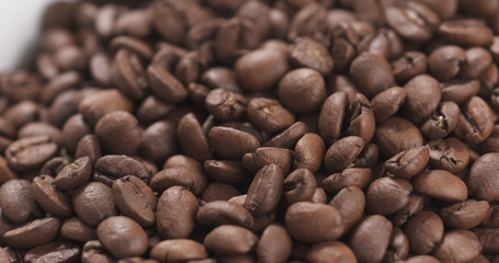 closeup coffee beans falling into bowl