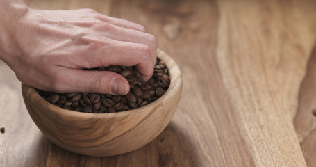 man hand check coffee beans in bowl on table