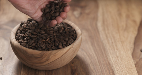 man hand check coffee beans in bowl on table