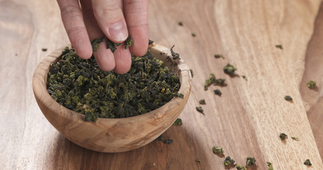 man hand check dried tea leaves in bowl on table