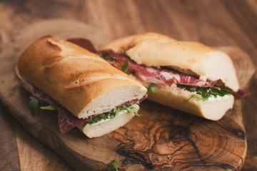 baguette sandwiches with coppa ham on wood board
