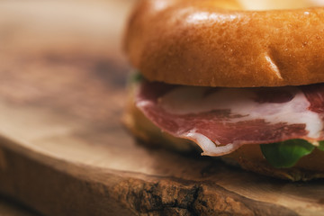 bagel with coppa and cream cheese on wood boar