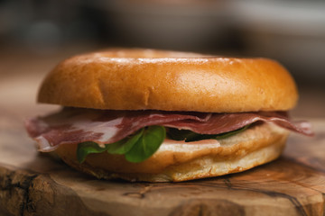 bagel with coppa and cream cheese on wood boar