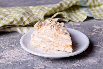 Cake Napoleon on a white plate, close up, horizontal