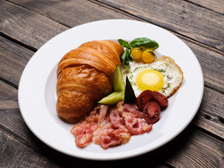 Fresh croissant with ham and salad