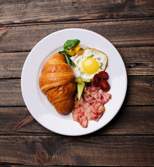 Fresh croissant with ham and salad