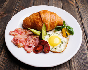 Fresh croissant with ham and salad