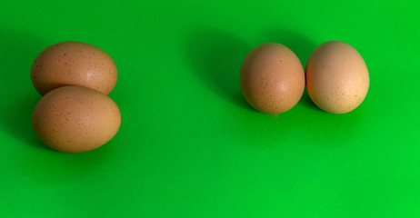 Abstract picture of Easter, two groups with two eggs on a uniformly green background.