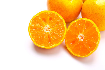 Fresh orange cut in half on a white background.