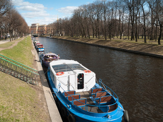 Naklejka premium Boats near the shore on the Moika River in St. Petersburg in April on a warm day