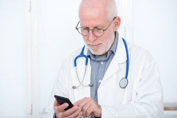 mature doctor on phone in his office