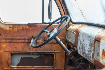 Steering wheel inside an old truck with the rusted 
