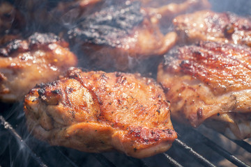 Grilled chicken thigh on the flaming grill