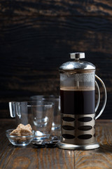 freshly brewed coffee in the french press on wooden table, vertical