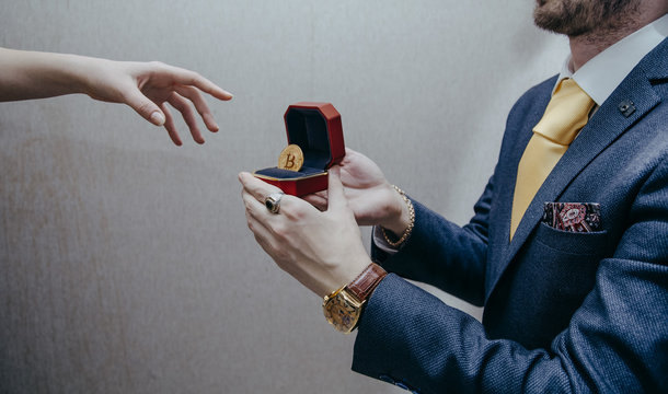 a man holds an enlarged box with bitcoin