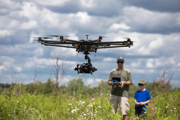 Fototapeta na wymiar learning to fly a drone, father trains son piloting drone