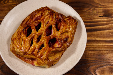 Delicious cherry strudel on wooden table