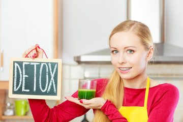 Woman holding vegetable juice and detox sign