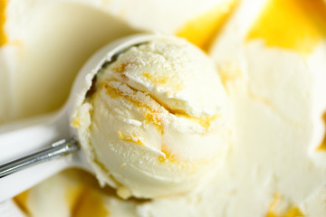 Vanilla ice cream scoop background. Summer food concept, copy space, top view. Scooped texture. Scooping out yellow mango ice-cream.