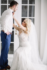 Naklejka premium Bride and groom at the wedding Day. Wedding couple, happy newlywed woman and man, in a beautiful hotel room, studio. Loving couple. Bride and groom