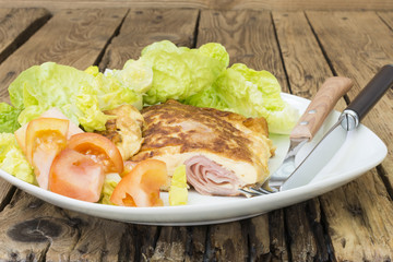 Tortilla, rellena de jamón de cerdo cocido , ensalada de tomate y lechuga