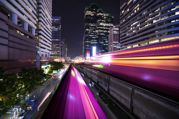 Naklejka premium abstract light tail of sky train in urban cityscape at night