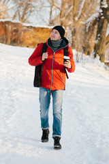 Fototapeta na wymiar Young man in red cloth in winter park