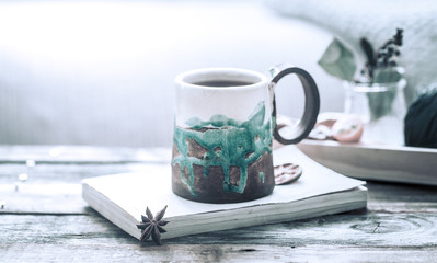book and a cup of tea on a wooden background, the concept of coziness and pastime