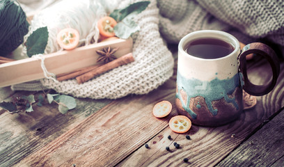 Fototapeta na wymiar still life a cozy cup of tea with kumquat on a wooden background, the concept of coziness and pastime