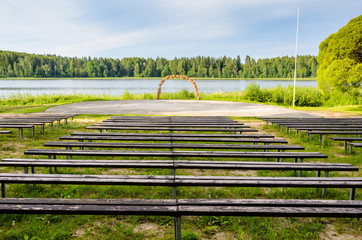 The open space for events near lake. Wooden benches. - 193005981